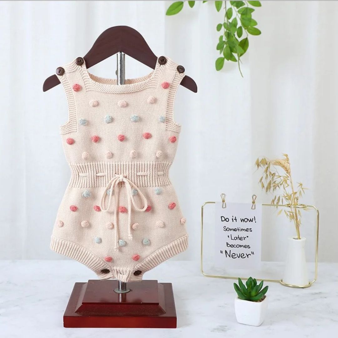 Ärmelloser Baby-Strickstrampler mit Plüsch-Bommeln